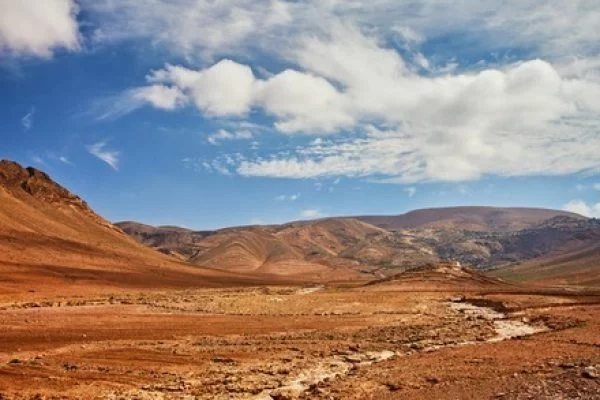 111403238-au-sud-du-maroc-pres-du-village-d-el-kelaa-m-gouna-un-chemin-de-terre-serpente-jusqu-aux-montagnes-qltk3zo72onoiy83bhf5hsil69ei6cz3yjsrr4i10g